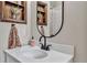 A clean bathroom featuring modern black fixtures, a decorative mirror, and framed artwork at 24121 Landing Dr, Lutz, FL 33559