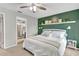 Inviting bedroom with a green accent wall, a ceiling fan and doorway leading to the modern bathroom at 24121 Landing Dr, Lutz, FL 33559