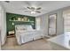 A serene bedroom featuring a green accent wall, ceiling fan and a view of the exterior at 24121 Landing Dr, Lutz, FL 33559