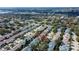 A bird's eye view displays a home with manicured landscaping nestled within a serene, tree-filled neighborhood at 2559 Stony Brook Ln, Clearwater, FL 33761