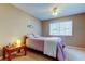 Bedroom with a ceiling fan, dresser, and side table sits next to a bright window at 2559 Stony Brook Ln, Clearwater, FL 33761