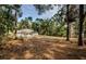 Expansive backyard featuring lush trees and a cozy hot tub, ideal for relaxation and outdoor enjoyment at 26890 Hiawatha Blvd, Brooksville, FL 34601