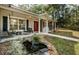 Cozy front porch featuring a swing and seating area, complemented by a charming koi pond and landscaped garden at 26890 Hiawatha Blvd, Brooksville, FL 34601