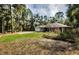 Well-maintained home featuring a green lawn, mature trees, and an inviting front facade with a two-car garage at 26890 Hiawatha Blvd, Brooksville, FL 34601