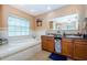 Bathroom featuring a soaking tub, granite countertops, double sinks, and tile floors at 26890 Hiawatha Blvd, Brooksville, FL 34601