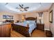 Spacious main bedroom features a tray ceiling, ceiling fan, wood floors, and a large wooden bed frame at 26890 Hiawatha Blvd, Brooksville, FL 34601