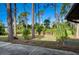 Landscaped backyard with mature trees and a large grassy area at 3241 Rogue St, North Port, FL 34291