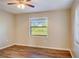 Bedroom with wood-look floors, window with blinds, and ceiling fan at 3241 Rogue St, North Port, FL 34291