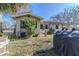 Side view of backyard with lawn, storage, mature trees, and patio furniture at 3512 Haines N Rd, St Petersburg, FL 33704