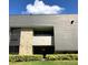 Exterior view of building with brick accents, a balcony, and well-maintained green shrubbery at 36750 Us Highway 19 N # 17-111, Palm Harbor, FL 34684