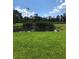 Scenic pond surrounded by lush greenery and mature trees under a bright blue sky with scattered clouds at 36750 Us Highway 19 N # 17-111, Palm Harbor, FL 34684