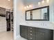 Bathroom featuring double vanity with dark wood cabinets and a quartz countertop with a closet view at 415 5Th N St, Safety Harbor, FL 34695