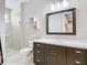 This bathroom offers a framed mirror over a vanity with a glass shower and decorative shelving at 415 5Th N St, Safety Harbor, FL 34695