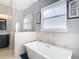 Relaxing bathroom features a modern soaking tub, a window and separate glass enclosed shower at 415 5Th N St, Safety Harbor, FL 34695