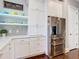 Kitchen showcasing custom white cabinets, stainless steel refrigerator, and open shelving at 415 5Th N St, Safety Harbor, FL 34695