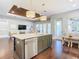 Kitchen island with a stainless steel dishwasher and hardwood floors extending into the living area at 415 5Th N St, Safety Harbor, FL 34695