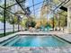 Backyard pool with water features surrounded by a patio and screen enclosure at 415 5Th N St, Safety Harbor, FL 34695