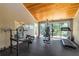 Home gym featuring a wood paneled ceiling, mirrored wall, exercise equipment, and sliding glass doors at 4212 126Th W St # 401, Cortez, FL 34215