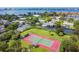 Aerial view of a well-maintained tennis court surrounded by lush landscaping in a waterfront community at 4212 126Th W St # 401, Cortez, FL 34215