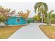 Bright blue house with a curved driveway and tropical landscaping at 4643 Bay Crest Dr, Tampa, FL 33615