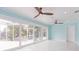 Open living space with light blue walls, white floors, and sliding doors to the pool area at 4643 Bay Crest Dr, Tampa, FL 33615