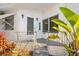 Close up of front porch with painted white wood plank, metal railing, steps, and tropical foliage at 4851 W Gandy Blvd # B2L25, Tampa, FL 33611