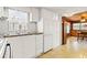 A well-lit kitchen with white cabinets, tiled walls, and a double basin sink beneath a window at 4851 W Gandy Blvd # B2L25, Tampa, FL 33611