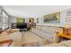 Living room showcasing tile flooring, neutral walls, and a collection of books, and a large wall painting at 4851 W Gandy Blvd # B2L25, Tampa, FL 33611