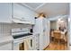 Bright kitchen featuring white appliances, cabinetry, and unique backsplash at 4917 Puritan Cir, Tampa, FL 33617