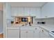 Functional kitchen offering white cabinetry and modern appliances, and open view into the living room at 4917 Puritan Cir, Tampa, FL 33617