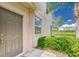 A close-up of the front door, accented by a column and framed by green shrubs and a distant pond at 4925 White Sanderling Ct, Tampa, FL 33619