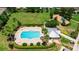 Aerial view of a neighborhood pool with lounge chairs and a community center at 4925 White Sanderling Ct, Tampa, FL 33619