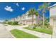 A sidewalk view of two-story homes, each with a two-car garage, lush lawns and palm tree accents at 4925 White Sanderling Ct, Tampa, FL 33619