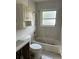 Outdated bathroom with pink tile, shower over tub, vanity, and toilet at 50 Acacia St, Clearwater Beach, FL 33767