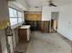 Unfinished kitchen with exposed block walls, view to backyard, and damaged floors at 50 Acacia St, Clearwater Beach, FL 33767