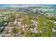 An aerial view shows the neighborhood homes surrounded by lush greenery with water in the distance at 5308 Ben Hur Dr, St Petersburg, FL 33708