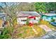 Bird's eye view of a cute white and red trimmed home situated on a well-kept lawn surrounded by tall trees at 5308 Ben Hur Dr, St Petersburg, FL 33708