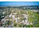 Aerial view showing neighborhood homes surrounded by lush greenery with water in the distance at 5308 Ben Hur Dr, St Petersburg, FL 33708