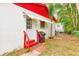 Rear view of a single story home featuring a white awning covered door, red steps, and minimal backyard space at 5308 Ben Hur Dr, St Petersburg, FL 33708