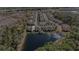 Aerial view of community overlooking a pond showcases lush surroundings, pool, and modern townhome architecture at 5507 Cumberland Star Ct, Lutz, FL 33558