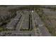 Aerial view of a community with rows of townhomes, a pool, and a picturesque pond surrounded by greenery at 5507 Cumberland Star Ct, Lutz, FL 33558