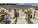 Exterior of townhome featuring a two-car garage, neutral color scheme, green shutters, and palm trees at 5507 Cumberland Star Ct, Lutz, FL 33558