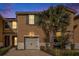 Exterior daytime view of townhome featuring a one-car garage, neutral color scheme, and a palm tree at 5507 Cumberland Star Ct, Lutz, FL 33558