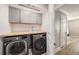 Efficient laundry room with gray cabinetry, butcher block countertop, and modern washer and dryer at 5507 Cumberland Star Ct, Lutz, FL 33558