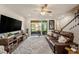 Cozy living room featuring a comfortable leather sofa, a large television, and seamless access to an outdoor patio area at 5507 Cumberland Star Ct, Lutz, FL 33558