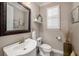 Neutral powder room features a pedestal sink, framed mirror, and a window with shutters at 5507 Cumberland Star Ct, Lutz, FL 33558