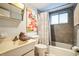 Bathroom featuring gray tile in the shower, floral artwork and a mirrored cabinet at 5892 Easy St # L25, Bradenton, FL 34207