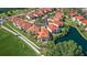 A lovely aerial view of residences with red tile roofs surrounded by lush greenery and a serene pond at 6105 Mirada Cir, St Petersburg, FL 33715