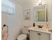 Cozy half bathroom features a white vanity, framed mirror, and art on the wall at 6105 Mirada Cir, St Petersburg, FL 33715