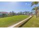 Exterior shot features a golf course with palm trees and residences, under a clear blue sky at 6105 Mirada Cir, St Petersburg, FL 33715